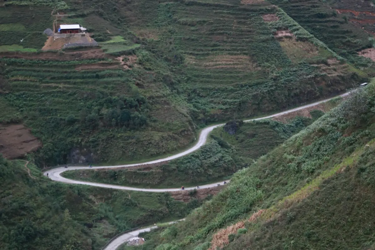 Luftbild einer kurvigen Straße über terrassierte Hänge in Ha Giang