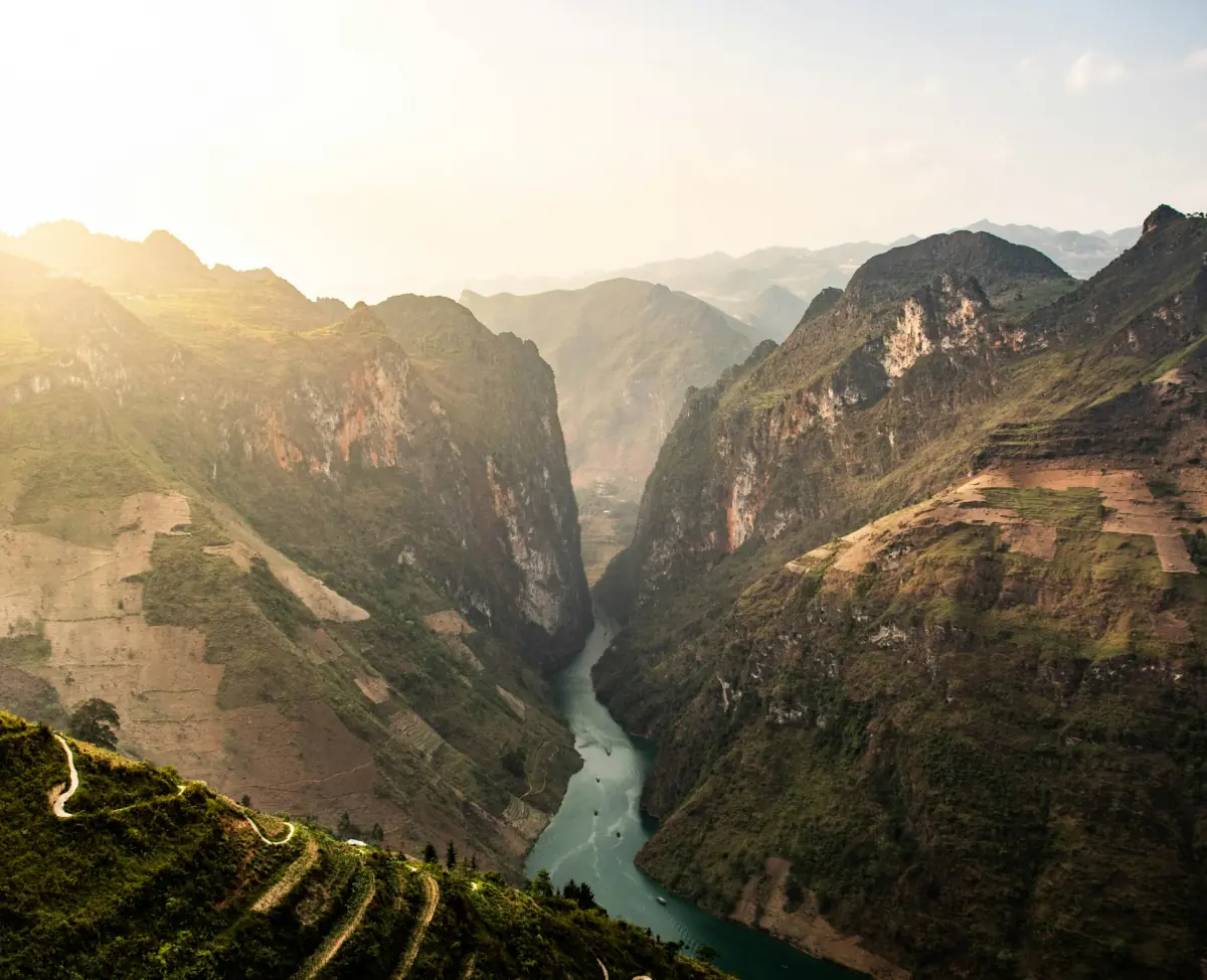 Flussschlucht zwischen steilen Felswänden im warmen Abendlicht in Ha Giang