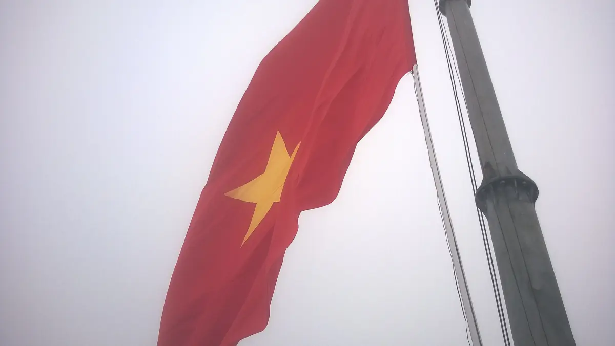 Rote Nationalflagge mit gelbem Stern über dem Fahnenturm von Lung Cu