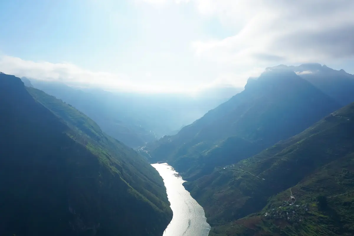 Nho Que River in a mountain valley with hazy ridges and light cloud