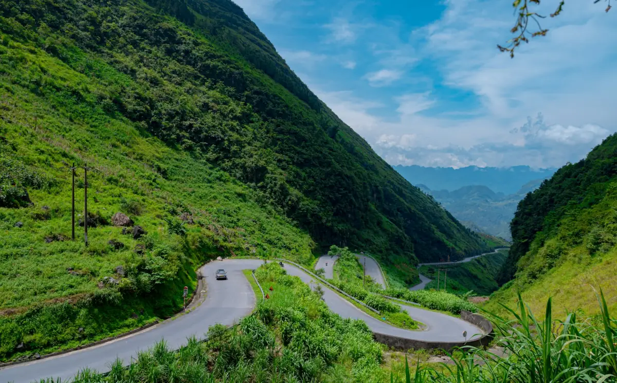 Sonnenbeschienene Haarnadelkurven einer Bergstraße in Ha Giang